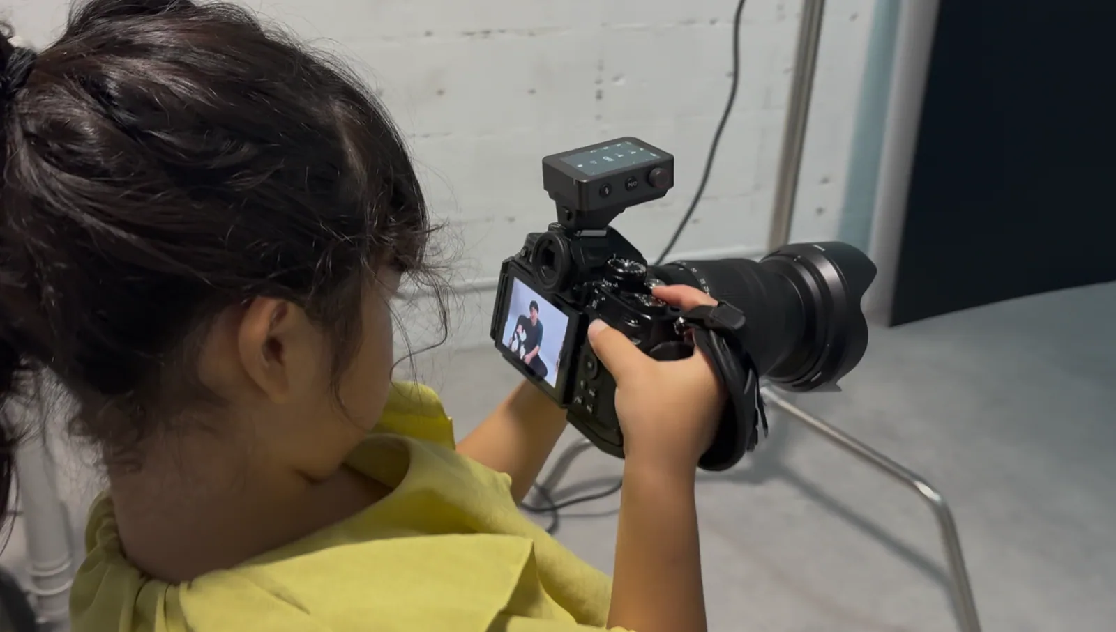 カメラを構え、画面を見ながら構図を決める子ども